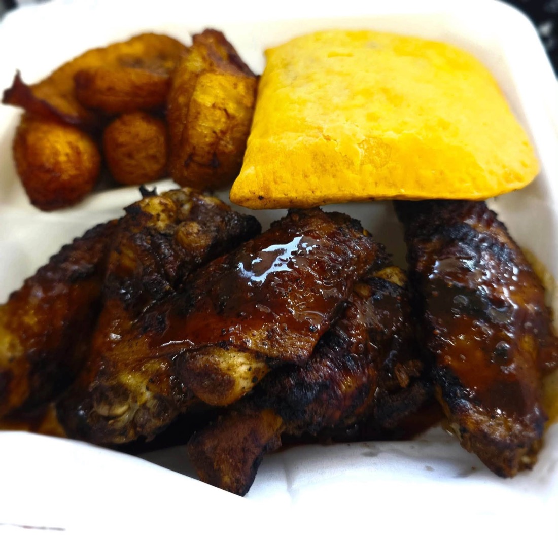 Jamaican jerk wings with fried plantains and a beef patty